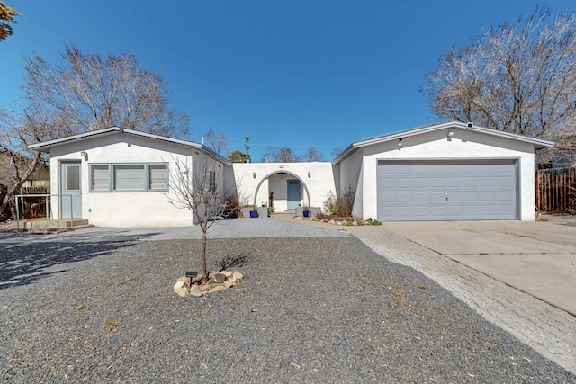 view of front of property with an attached garage, concrete driveway, and stucco siding