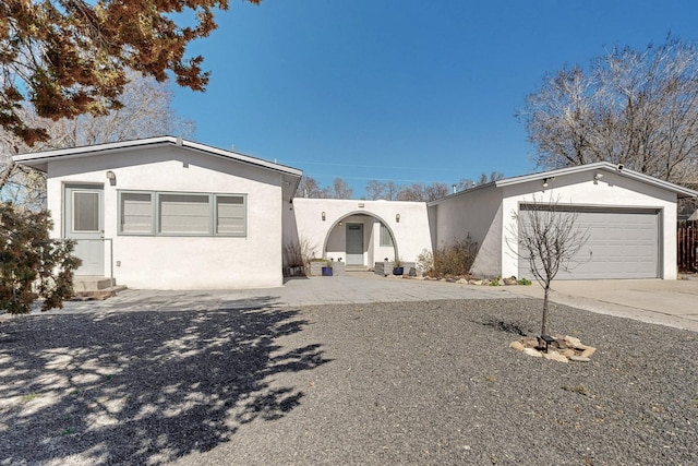 view of front of property featuring driveway, entry steps, an attached garage, and stucco siding