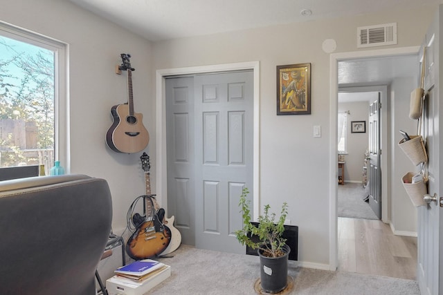 home office with visible vents, light wood-style flooring, and baseboards