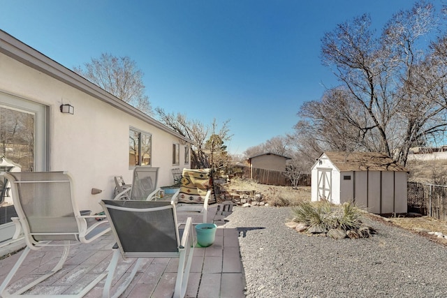 view of patio / terrace featuring a storage shed, a fenced backyard, and an outdoor structure