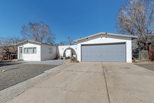 single story home featuring driveway, an attached garage, fence, and stucco siding