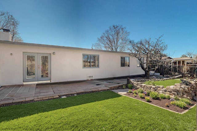 back of house featuring french doors, a yard, stucco siding, visible vents, and a patio area