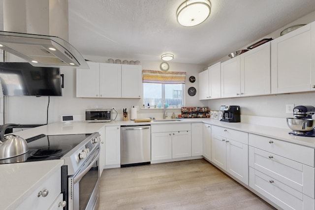 kitchen with white cabinets, appliances with stainless steel finishes, extractor fan, light countertops, and a sink