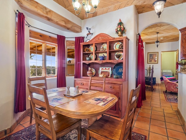 dining area featuring wooden ceiling, light tile patterned floors, arched walkways, and a chandelier