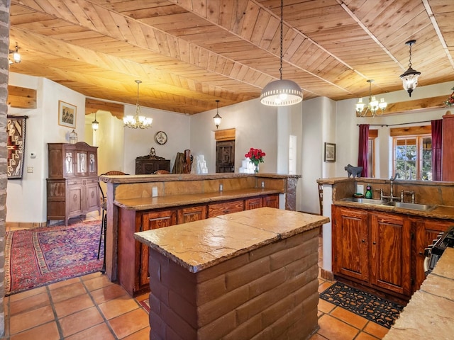 kitchen featuring wood ceiling, a notable chandelier, a kitchen island, and a sink