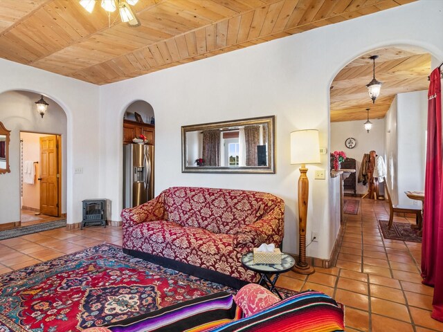 living room featuring arched walkways, wood ceiling, baseboards, and tile patterned floors