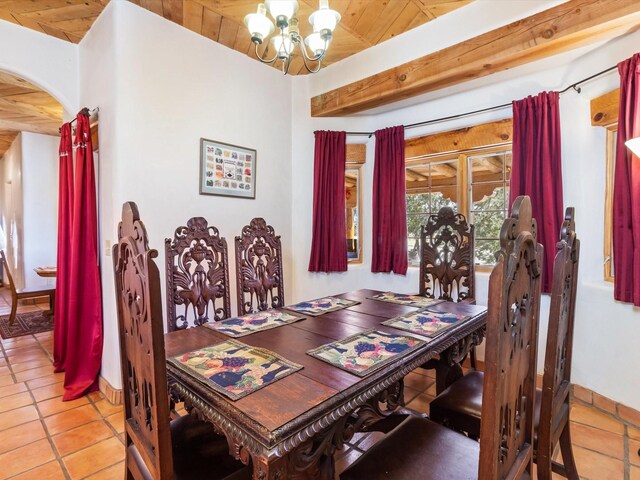 dining space with light tile patterned floors, baseboards, a chandelier, and arched walkways