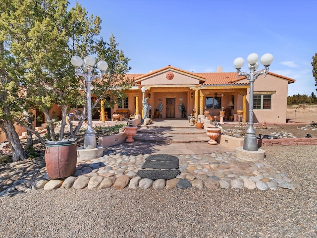 back of property with a patio area, a tile roof, and stucco siding