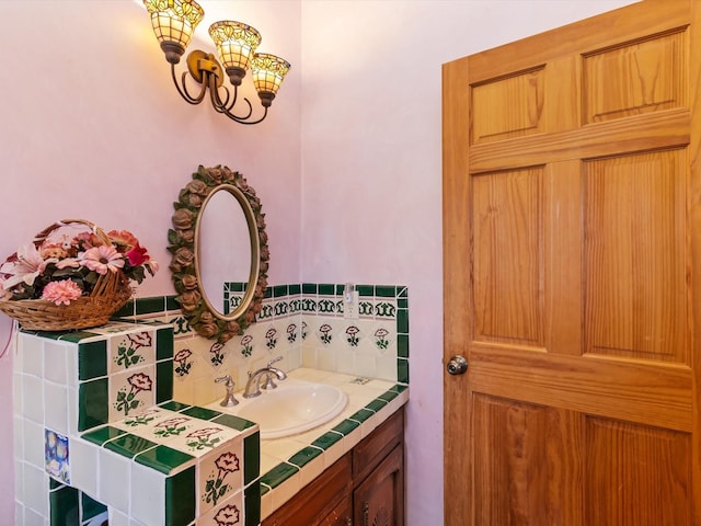 bathroom with backsplash, a notable chandelier, and vanity