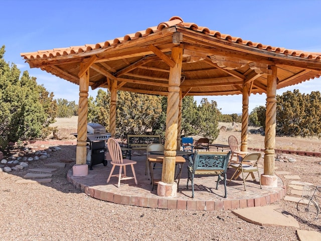 view of patio featuring outdoor dining space, a grill, and a gazebo