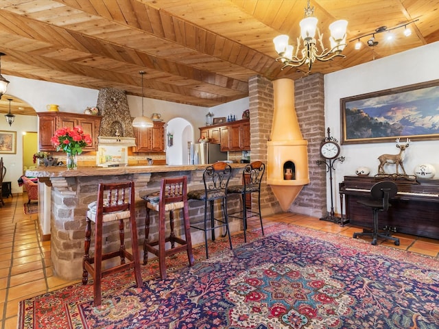 kitchen featuring arched walkways, freestanding refrigerator, wooden ceiling, and light tile patterned flooring