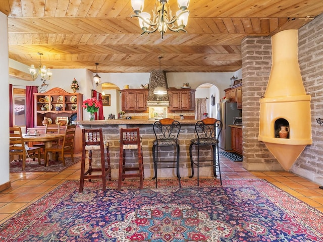 kitchen featuring a chandelier, tile patterned flooring, arched walkways, and stainless steel fridge with ice dispenser