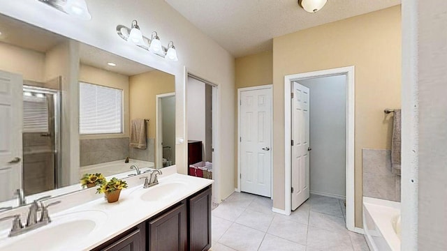 bathroom featuring tile patterned flooring, a sink, and a bath