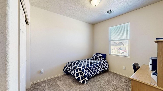 bedroom featuring baseboards, carpet, visible vents, and a textured ceiling