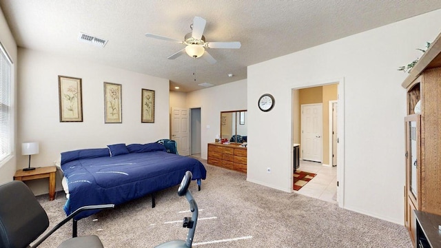 bedroom featuring baseboards, visible vents, a ceiling fan, light colored carpet, and a textured ceiling