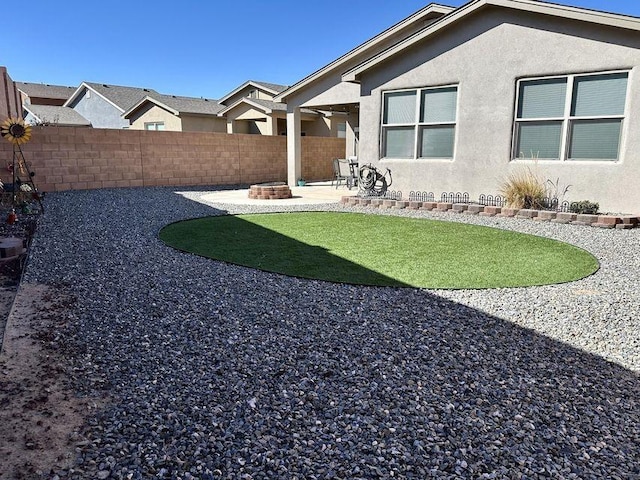 view of yard featuring fence, a fire pit, and a patio