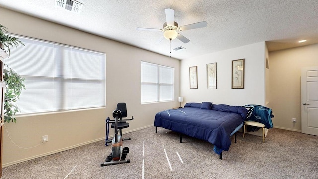 carpeted bedroom featuring baseboards, visible vents, and a textured ceiling