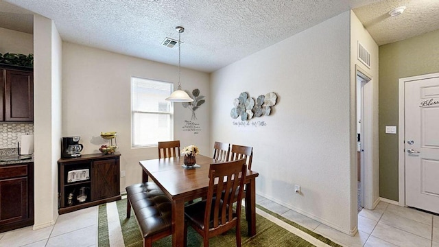 dining space featuring light tile patterned flooring, visible vents, and baseboards