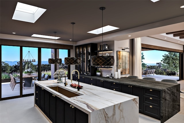 298 Brownell Howland, Santa Fe, NM 87501 - kitchen with a skylight, dark cabinets, a raised ceiling, healthy amount of natural light, and recessed lighting