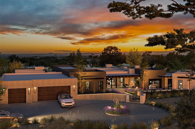 view of front of property with decorative driveway, an attached garage, and stucco siding