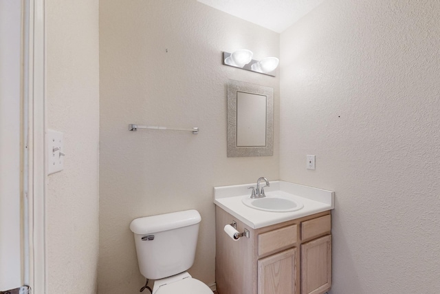 half bathroom with toilet and vanity