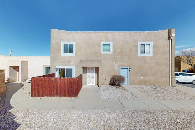 view of front of home with fence and stucco siding