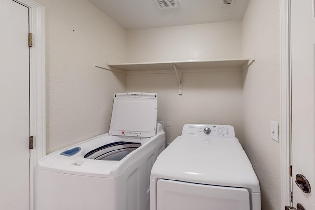 clothes washing area featuring laundry area, visible vents, and independent washer and dryer