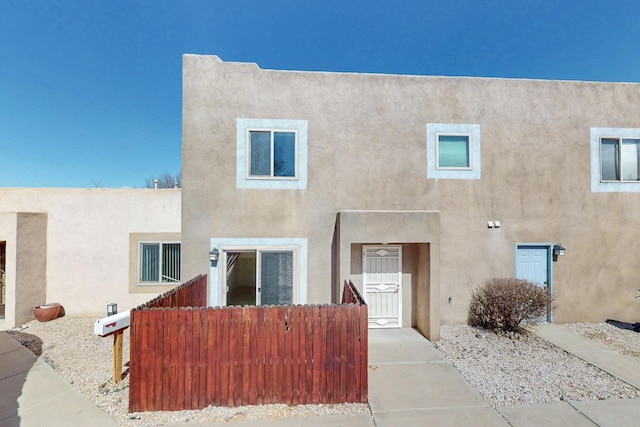 view of front of property featuring fence and stucco siding