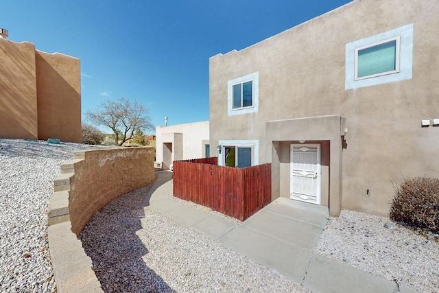 exterior space featuring a fenced front yard and stucco siding