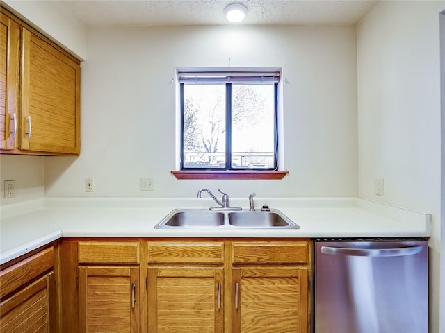 kitchen featuring a sink, a textured ceiling, light countertops, and stainless steel dishwasher