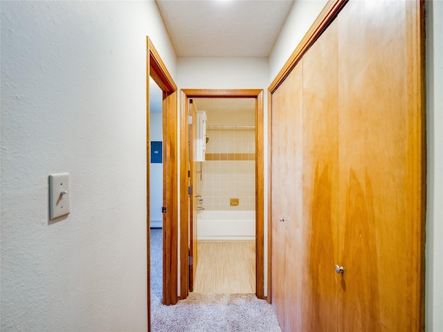 hallway with carpet floors and a textured wall