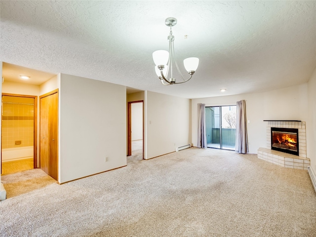 unfurnished living room with light carpet, a baseboard radiator, an inviting chandelier, a textured ceiling, and a fireplace