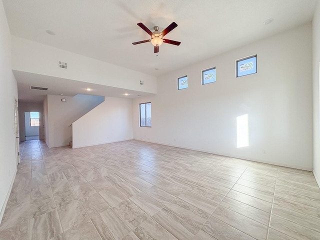 unfurnished room with ceiling fan, visible vents, and baseboards