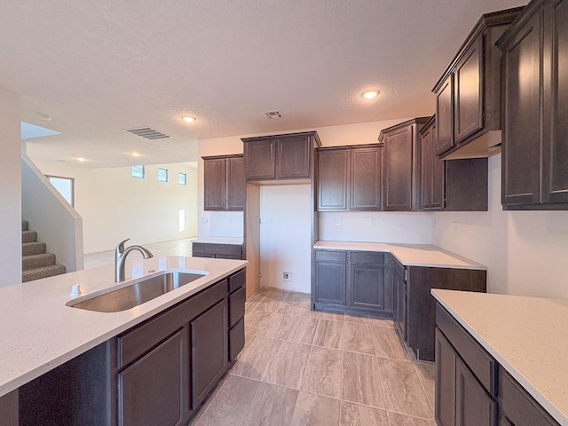 kitchen featuring visible vents, light countertops, a sink, and dark brown cabinetry