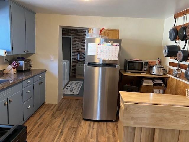 kitchen with light wood-style flooring, gray cabinets, and appliances with stainless steel finishes