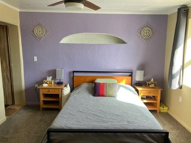 carpeted bedroom featuring baseboards, ornamental molding, and a ceiling fan