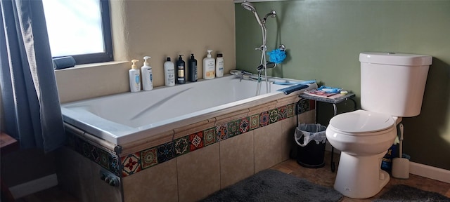 bathroom featuring tiled tub and toilet