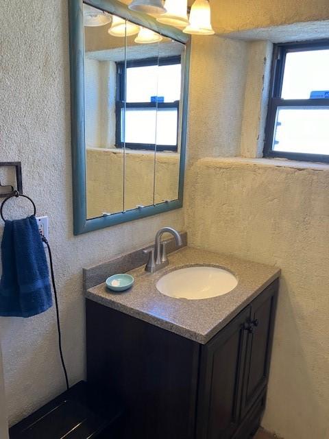 bathroom with vanity and a textured wall