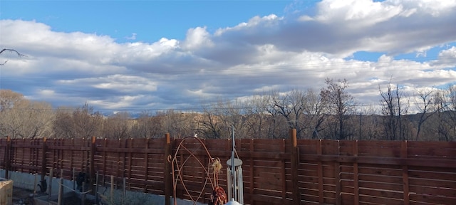 view of yard with a view of trees and fence