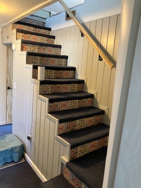 stairs featuring wood walls