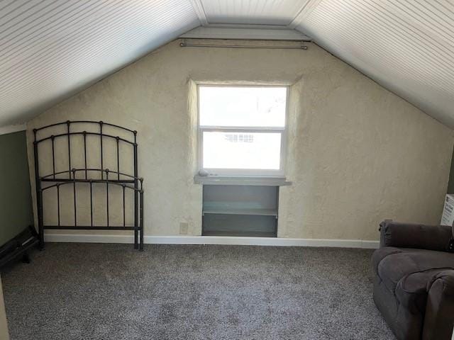 bonus room featuring carpet flooring, baseboards, lofted ceiling, and a textured wall