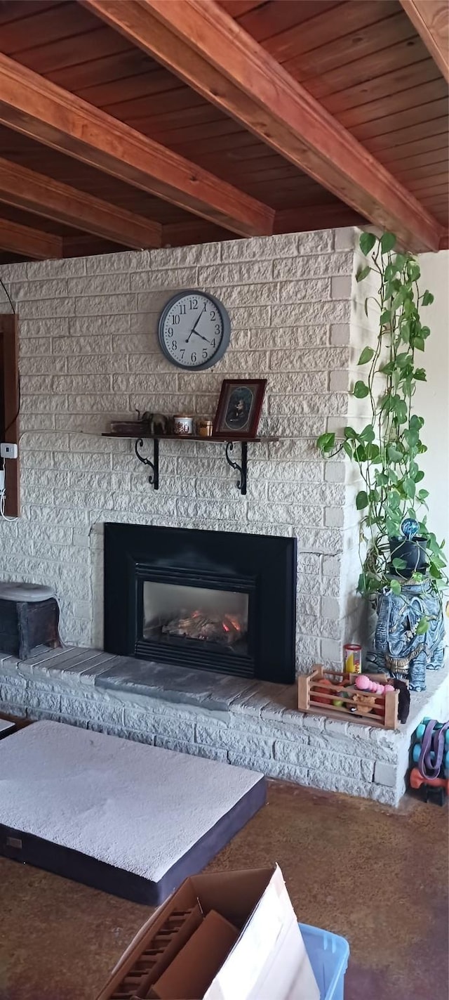 interior space with beam ceiling, wood ceiling, and a glass covered fireplace