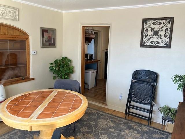 living area featuring crown molding, baseboards, and wood finished floors