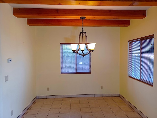 spare room featuring a chandelier, beamed ceiling, light tile patterned flooring, and baseboards