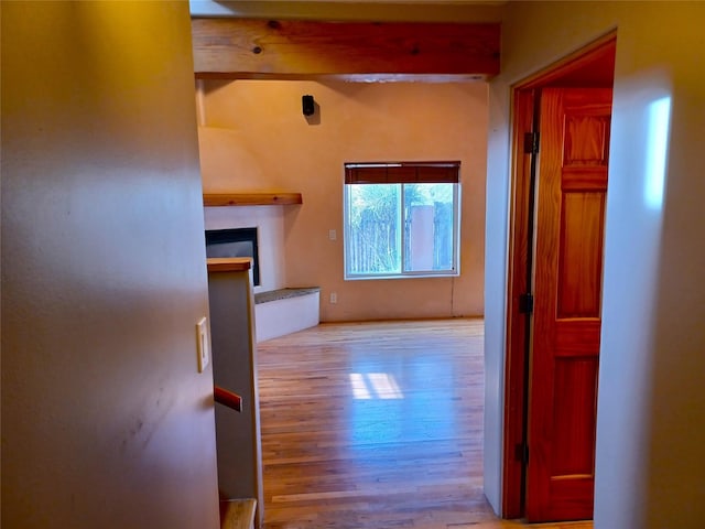 hall featuring beam ceiling and wood finished floors