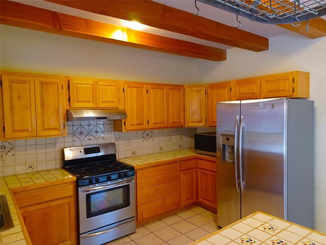 unfurnished living room featuring wood finished floors, beam ceiling, a glass covered fireplace, and wood ceiling