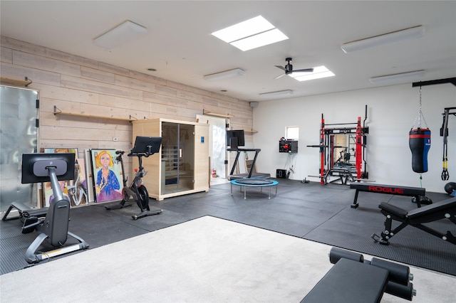 gym with a skylight and wooden walls