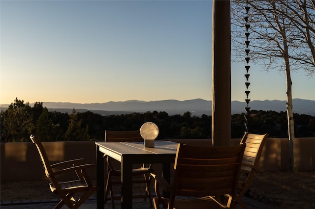 patio terrace at dusk with outdoor dining area and a mountain view