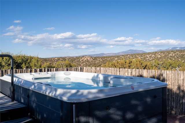 view of pool with a mountain view and a hot tub