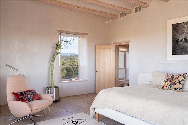 bedroom featuring beam ceiling and visible vents